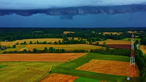 Towering storm front rolls in with shelf cloud above patchwork fields and Stock Footage 322147669