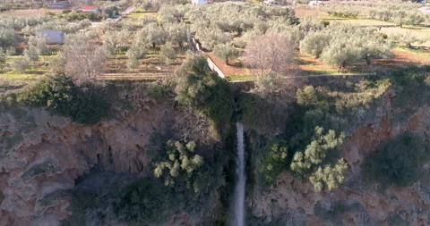 Towering waterfall next to olive grove aerial view from drone Stock Footage 146968859