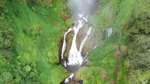 Towering waterfall with water flowing beneath it Stock Footage 239797171