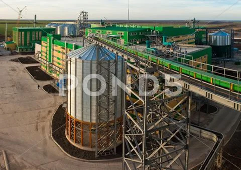 Towers of grain drying enterprise at sunny day Stock Photos