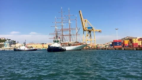 Towing a sailboat in port Stock Footage 313751609