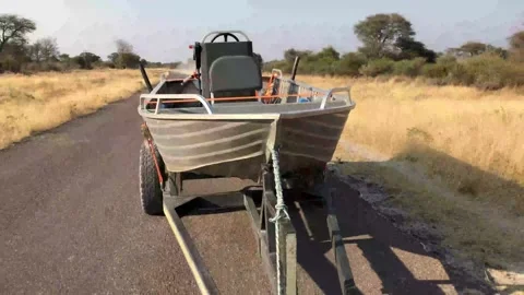 Towing a speed boat on a trailer down an asphalt road 库存影片 203839175