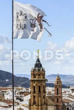 The town of Antequera with church towers and a ripped, weathered flag in the for Stock Photos