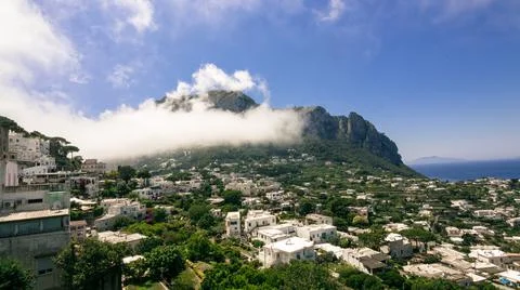 Town of capri during the day with a cloud passing nearby Stock Photos