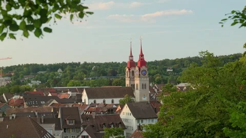 A town with a distinctive church featuring red spires and clock faces is Stock Footage 345848978