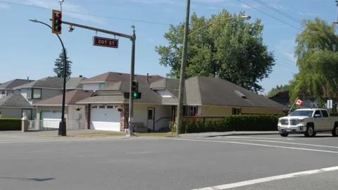 Town intersection. 207 street sign. Cars passing different directions. 库存影片 158019986