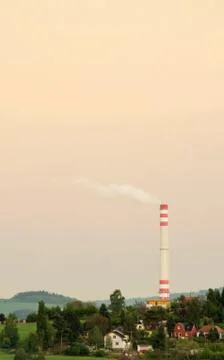 Town landscape in sunset with smoke stack. Stock Photos