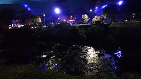 Town night lights reflecting in river water with bridge. Mirror water surface Stock Footage 324924692