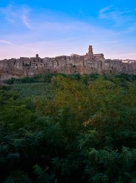 Town of Pitigliano in Tuscany, with wood of trees and cloudy sky Stock Photos