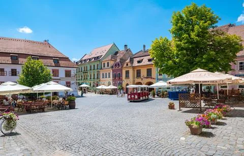 Town square with ancient light multi colored houses in Sighișoara, Romania Foto stock