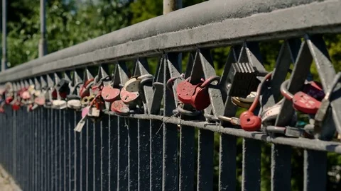 Town street. Wedding locks on a bridge railings left by enamored newlyweds. 4K Video stock 79716352