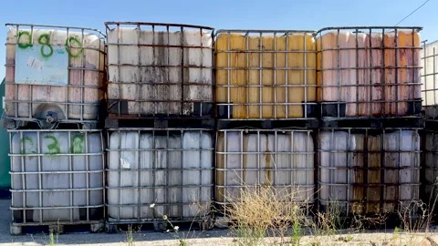 Toxic Plastic containers tanks with harmful chemical leaking piled one over Stock Footage 246323890