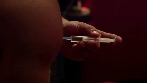 Toxic steroid injection liquid being infused on a arm by a bodybuilder, in Stock Footage 104298473