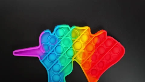 Toy antistress pop it in the shape of a unicorn spinning on a black background Stock Footage 157068376