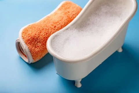 Toy bath with soap suds on a blue background. The concept of cleanliness, hyg Stock Photos