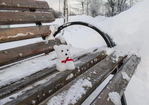 Toy bear on a bench in the winter Stock Photos