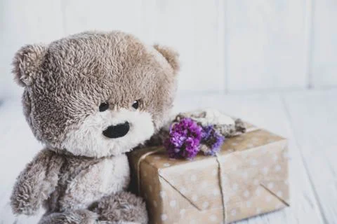 Toy bear with gift boxes on a light wooden background. Vintage background for Stock Photos