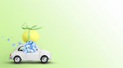 Toy car carrying an easter egg on the roof on a green background. Stock Photos