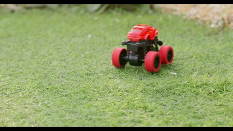 Toy car driving forward on grass, slow motion, no people Stock Footage 329681483