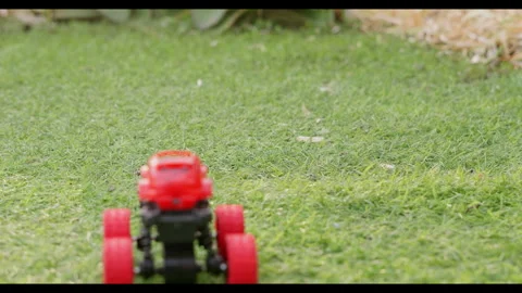 Toy car driving forward on grass, slow motion, no people Stock Footage 329681867