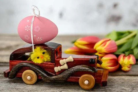 Toy car with an Easter egg and tulips Stock Photos
