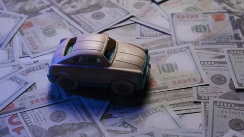 Toy car rotating on US dollar background – concept of car finance, leasing or in Stock Footage 306309966