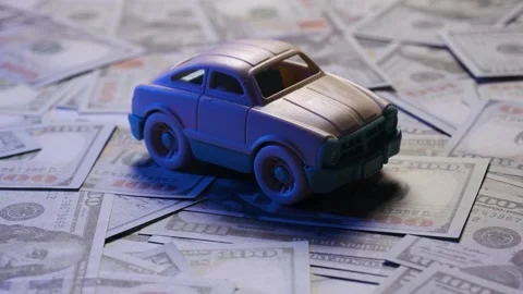 Toy car rotating on US dollar background – concept of car finance, leasing or in Stock Footage 306310001