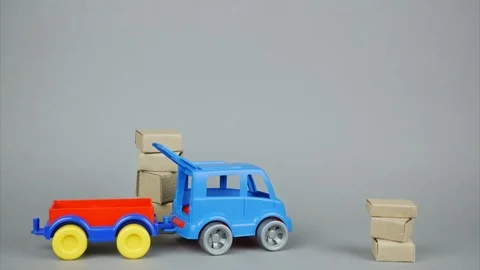 Toy car with trailer loads parcels in two places and leaves. Stop motion Stock Footage 103632012