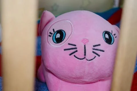 Toy cat behind the crib Stock Photos