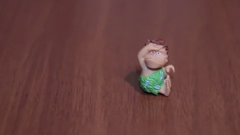Toy caveman sitting on a dark background cartoon mini Stock Footage 71890121