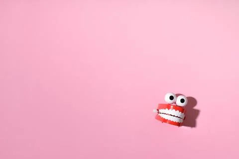 Toy clockwork jaws on a pink background with a place for text. Happy Halloween Foto stock