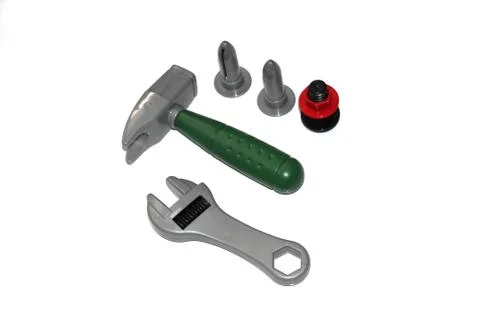 Toy construction tools on a white background. Hammer, wrench, nails and bolt. Stock Photos