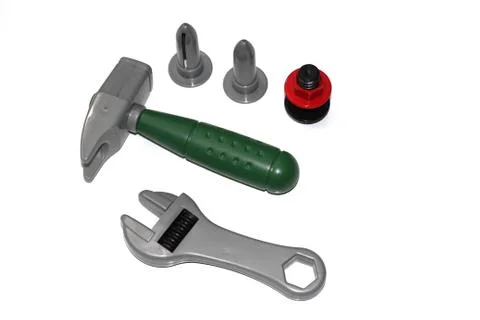 Toy construction tools on a white background. Hammer, wrench, nails and bolt. Stock Photos