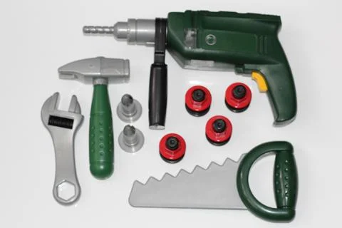 Toy construction tools on a white background. Hammer, wrench, nails and bolt. Stock Photos