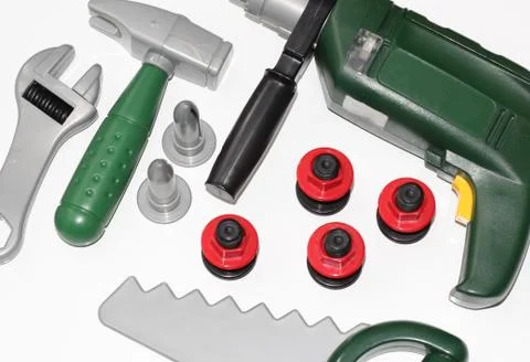 Toy construction tools on a white background. Hammer, wrench, nails and bolt. Stock Photos
