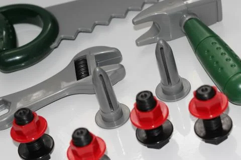 Toy construction tools on a white background. Hammer, wrench, nails and bolt. Stock Photos