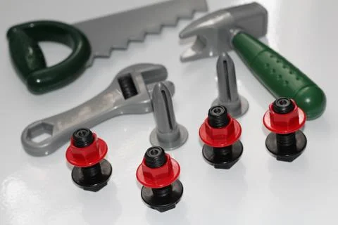 Toy construction tools on a white background. Hammer, wrench, nails and bolt. Stock Photos