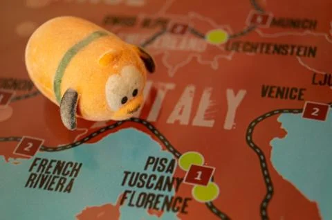 Toy dog is looking for a path on the map. Travel themed abstraction. Stock Photos