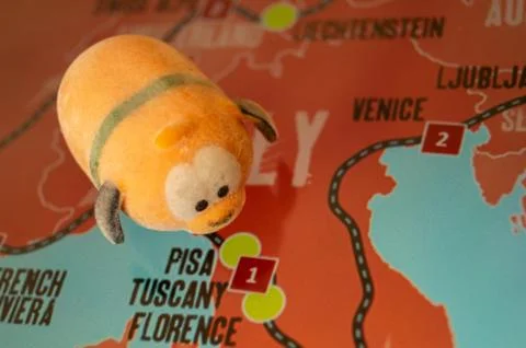 Toy dog is looking for a path on the map. Travel themed abstraction. Stock Photos