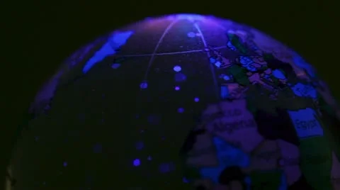 Toy Earth sphere with world map on it spins in color light Stock Footage 10852581