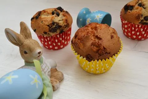 Toy Easter bunny and eggs, muffins on a pastel background. Stock Photos