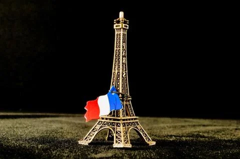 Toy of the Eiffel tower and the flag of France next to it Stock Photos
