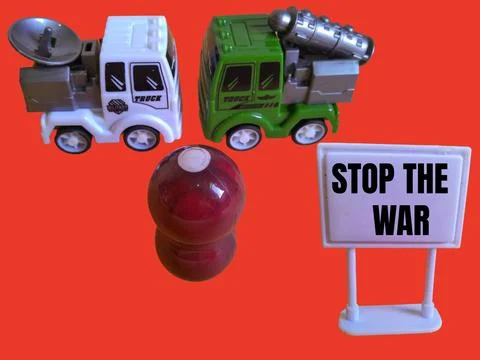 A toy figure is looking at two army trucks and the words stop the war Stock Photos