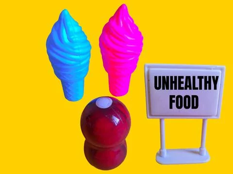 A toy figure is looking at two ice creams and the word unhealthy food Stock Photos