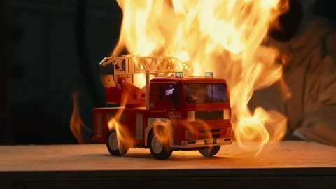 Toy fire engine epic stands on a background of fire Stock Footage 116479564