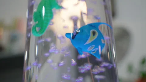 Toy fish floating in a bubble tube display Stock Footage 345860352