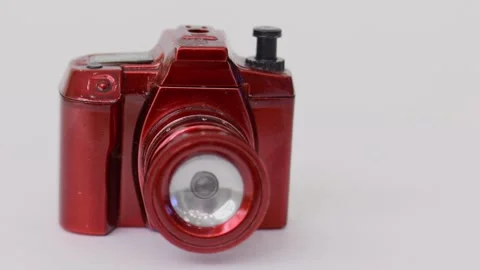 Toy flashlight in form of digital camera, rotates isolated on white Stock Footage 276375931