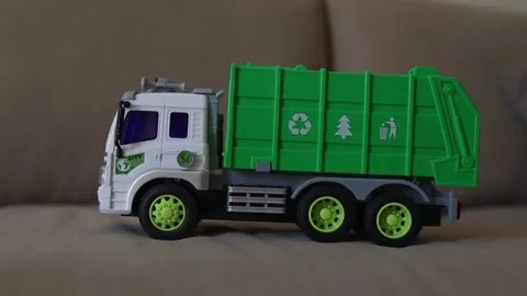 A toy garbage truck mounted on a surface with visible green parts Stock Footage 315507680