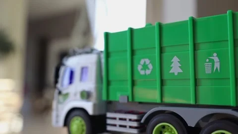 A toy garbage truck mounted on a surface with visible green parts Stock Footage 315507684