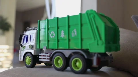 A toy garbage truck mounted on a surface with visible green parts Stock Footage 315507690